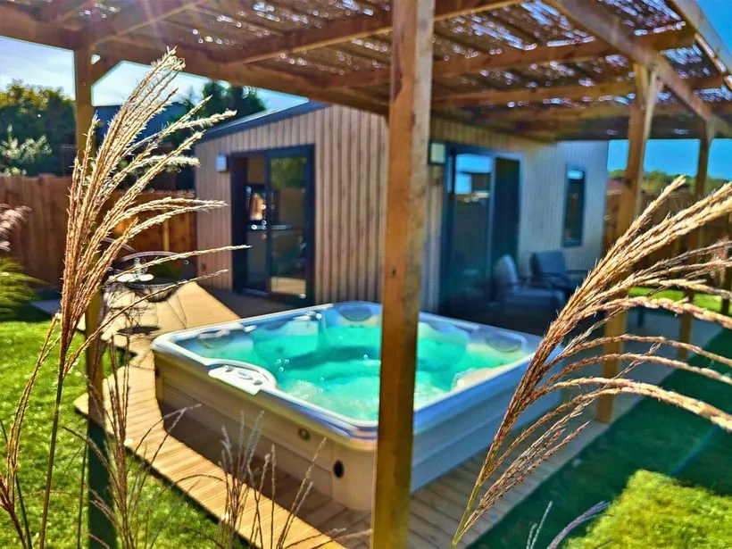 Jacuzzi privatif au soleil devant un cottage