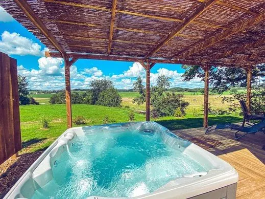 Jacuzzi privatif avec reflets bleus au Domaine des Gramin&eacute;es