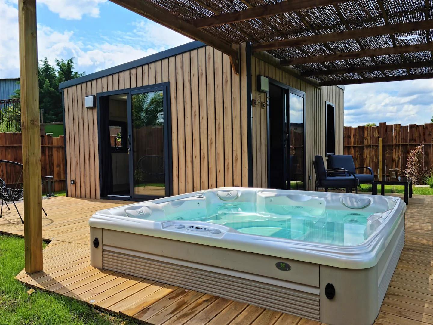 Le jacuzzi privatif du Cocon, sa terrasse en bois et son cottage indépendant