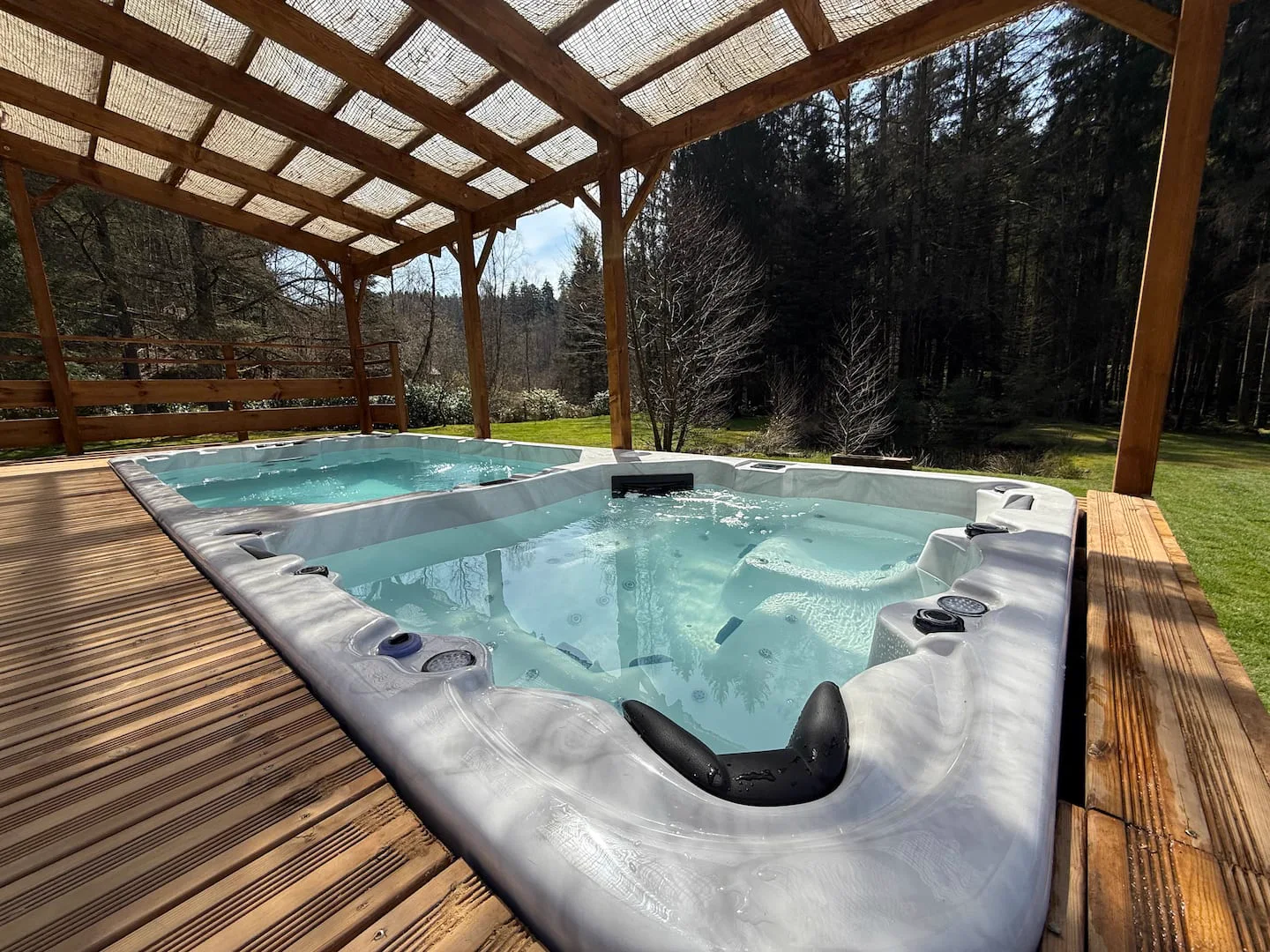 Spa de nage et jacuzzi sous la terrasse couverte · L’Écrin de la Forêt