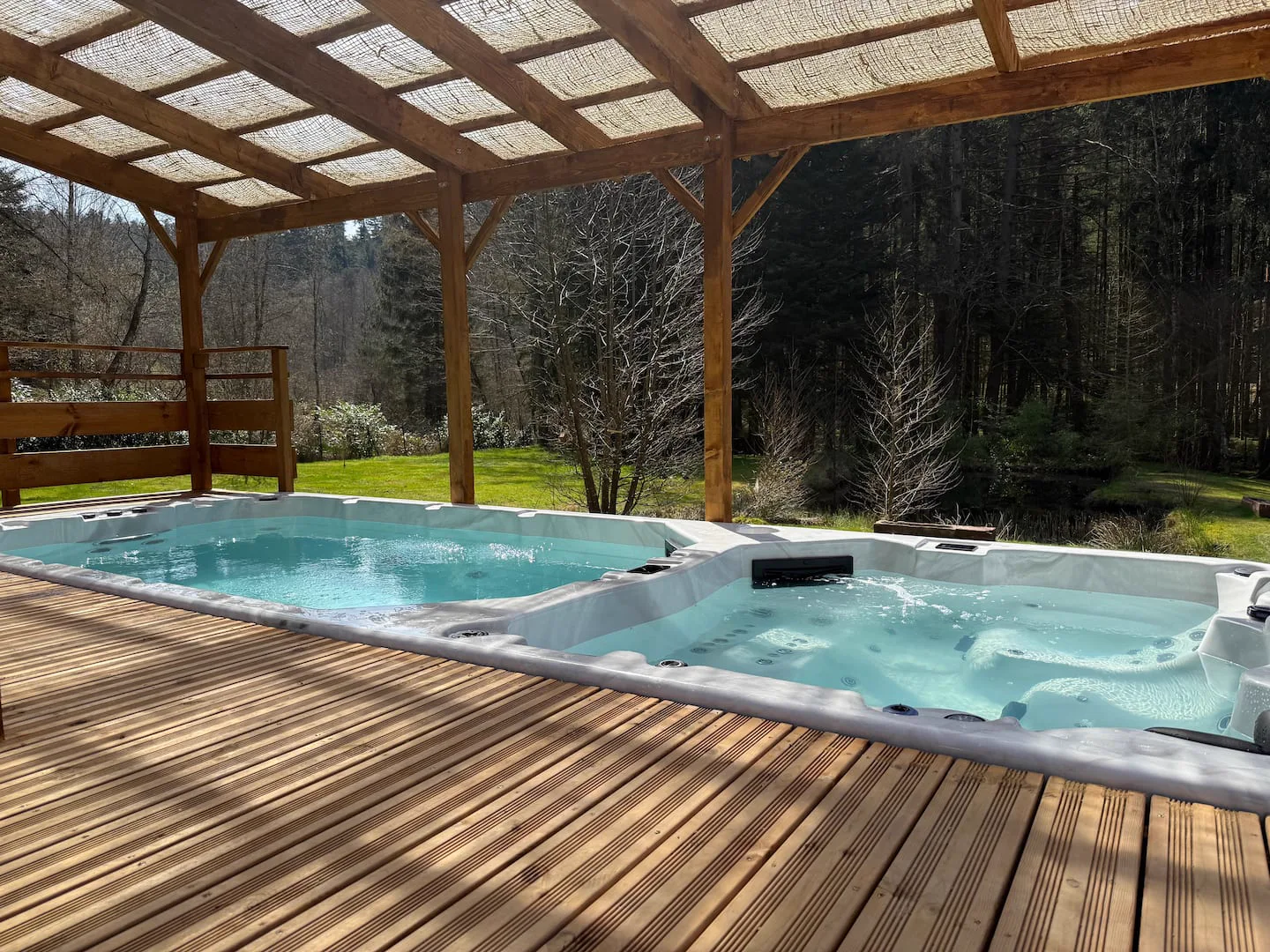 Spa de nage sous la couverture en bois · L’Écrin de la Forêt