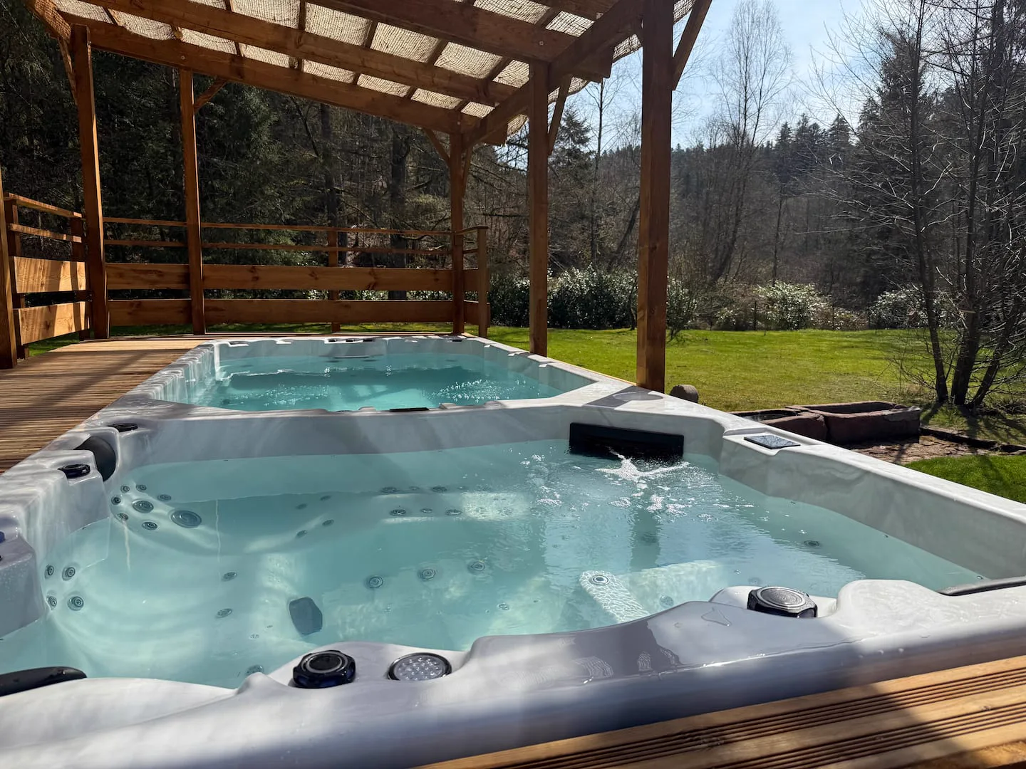 Jacuzzi privatif tourné vers la forêt · L’Écrin de la Forêt