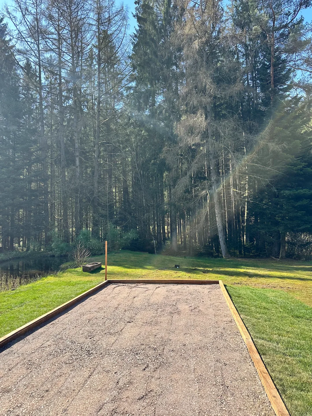 Terrain de pétanque au bord de la forêt · L’Écrin de la Forêt