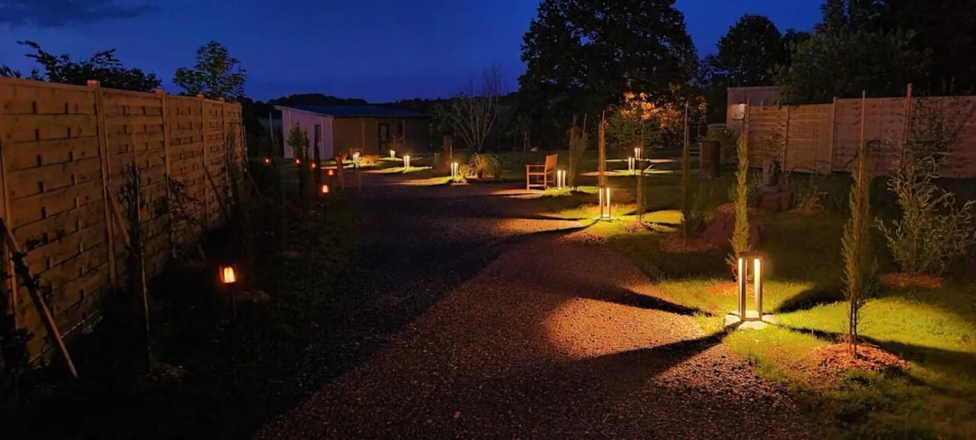 Allée réelle éclairée au Domaine des Graminées à la tombée du jour